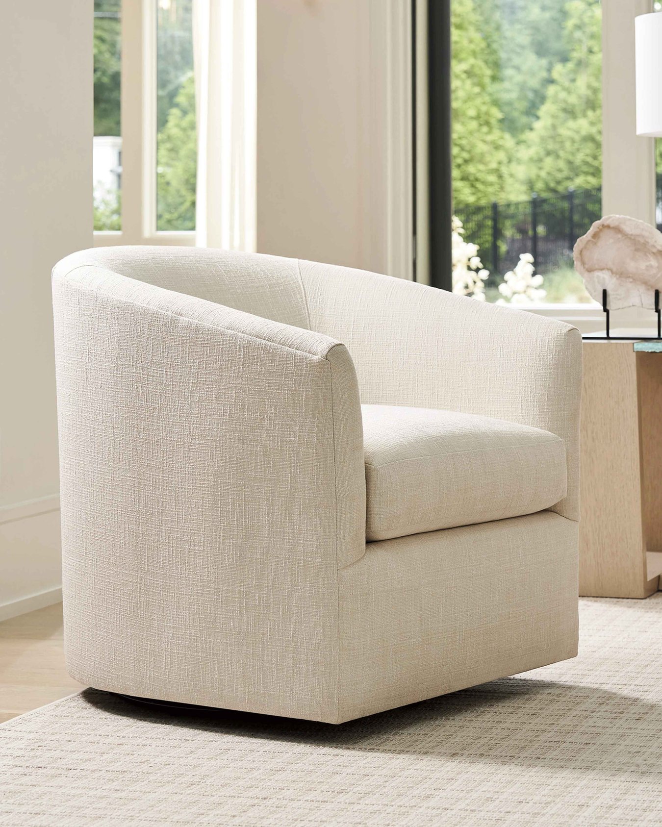 A white chair by a window, offering a cozy spot to relax and enjoy the view.