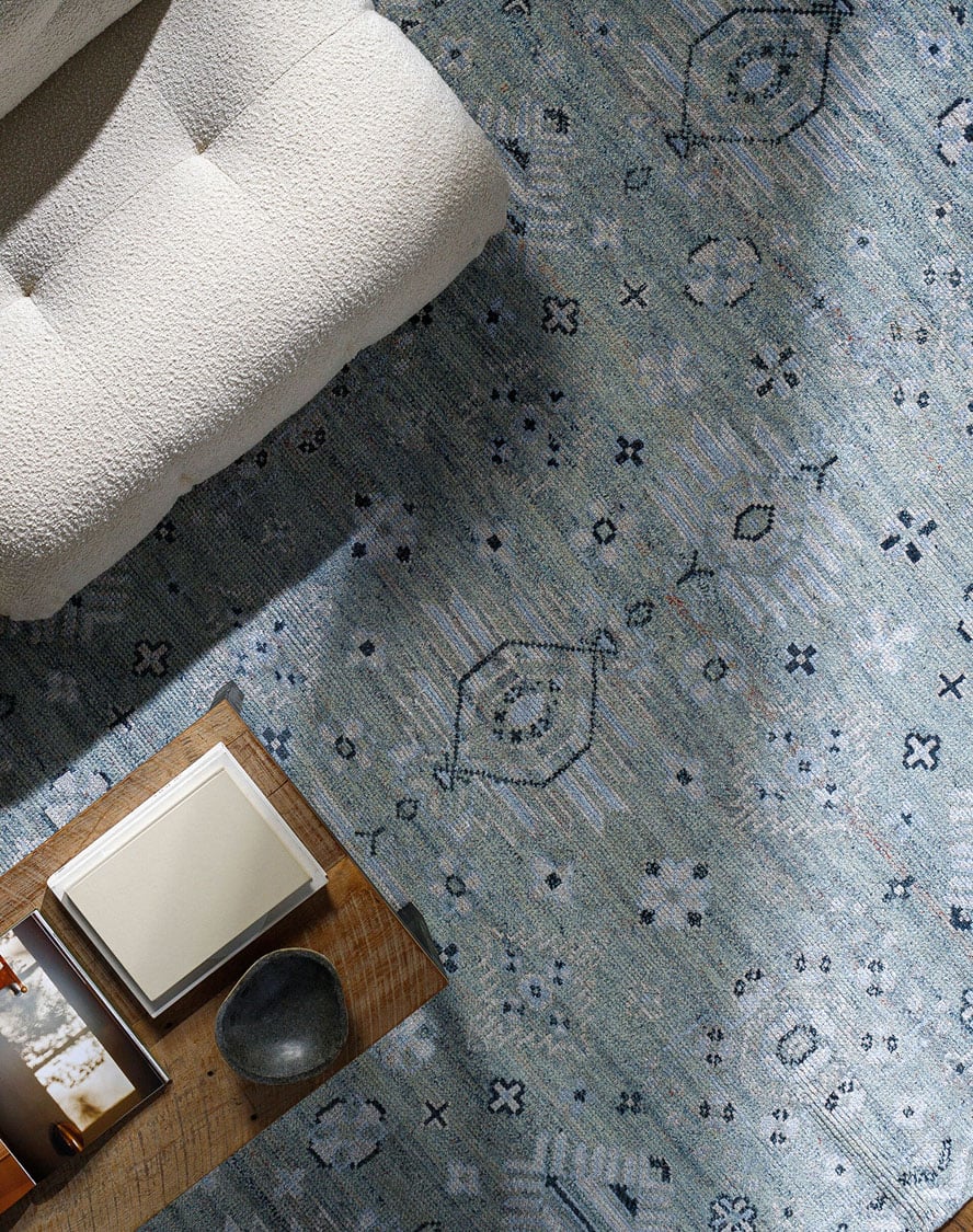 Cozy living space featuring a blue patterned area rug with subtle geometric motifs, perfect for adding depth and softness to modern interiors on a designer rug site.