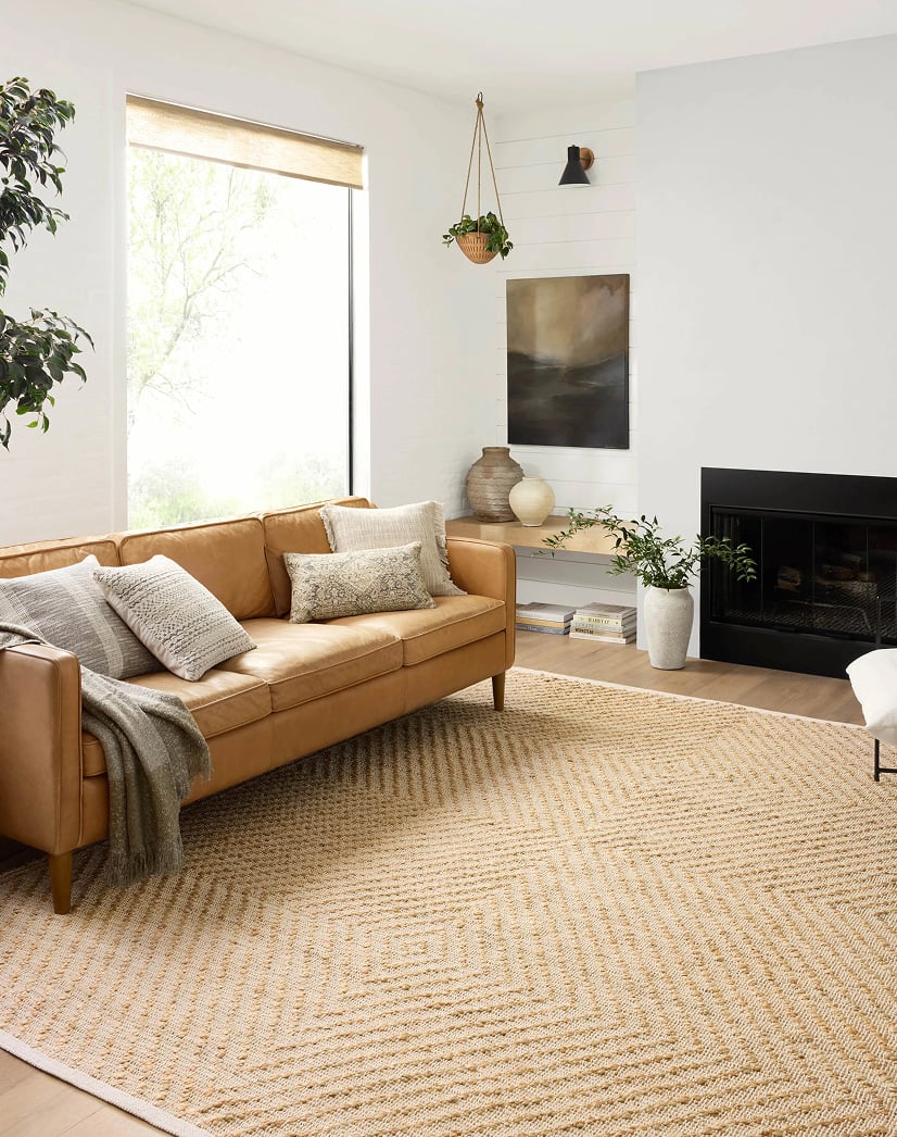 Bright, modern living room featuring a natural jute area rug with a diamond pattern, adding texture and warmth to a neutral space on a luxury rug site.