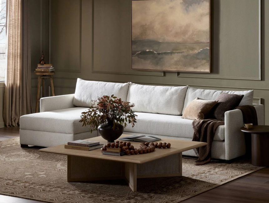 Neutral living room with sectional sofa, wood coffee table, and warm layered decor.