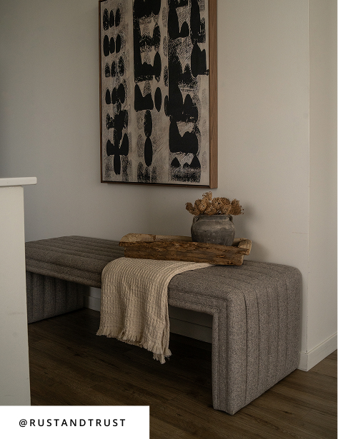 Entryway with channel-tufted bench, abstract wall art, wood tray, and neutral decor