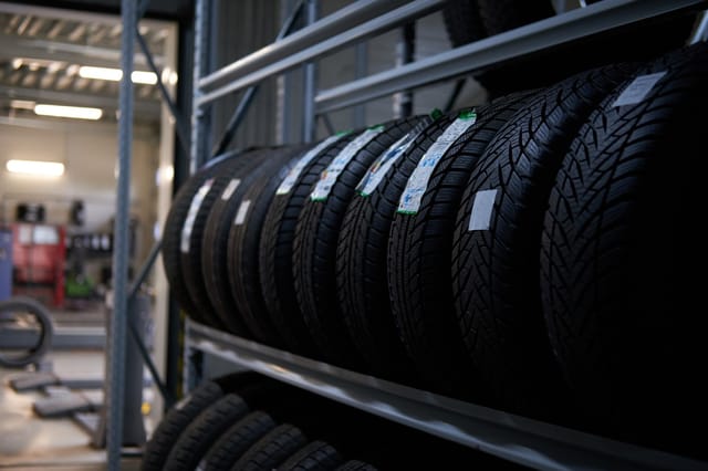 Rij nieuwe autobanden op een metalen rek in een garage of werkplaats