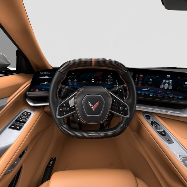 Interieur van een Corvette sportwagen met luxe tan leren bekleding, een stuurwiel van koolstofvezel met Corvette-logo en digitale dashboarddisplays.