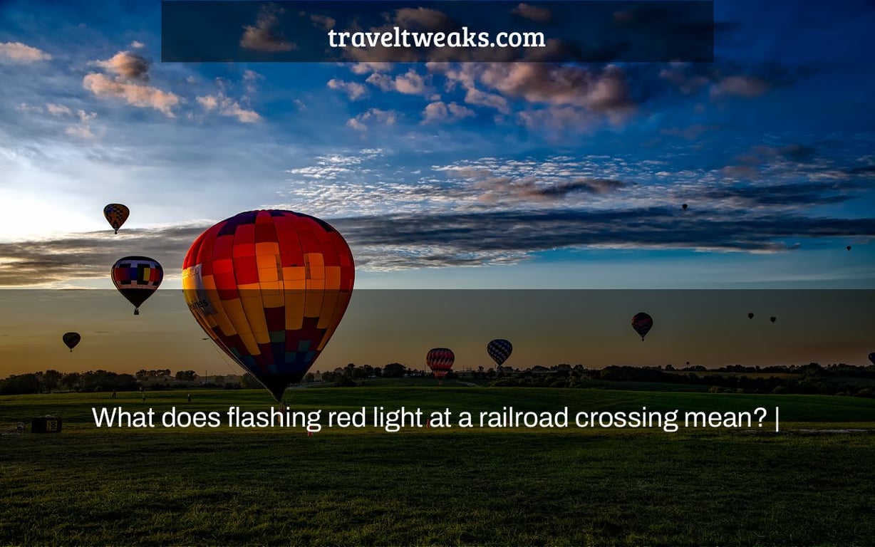 What does flashing red light at a railroad crossing mean? |