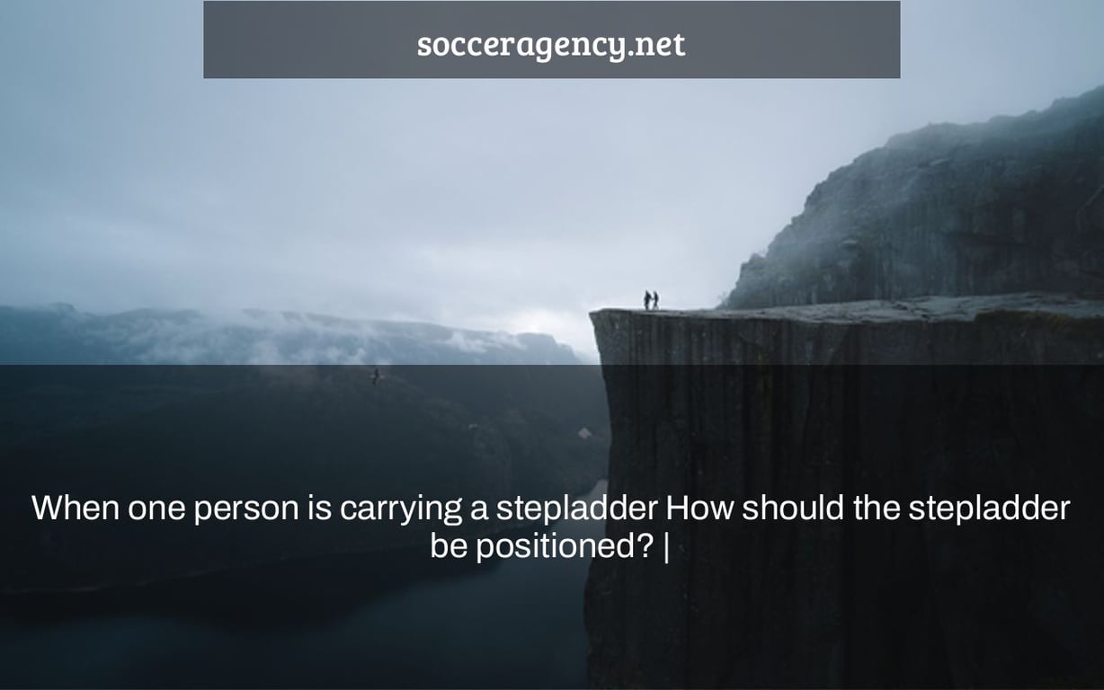 When one person is carrying a stepladder How should the stepladder be positioned? |