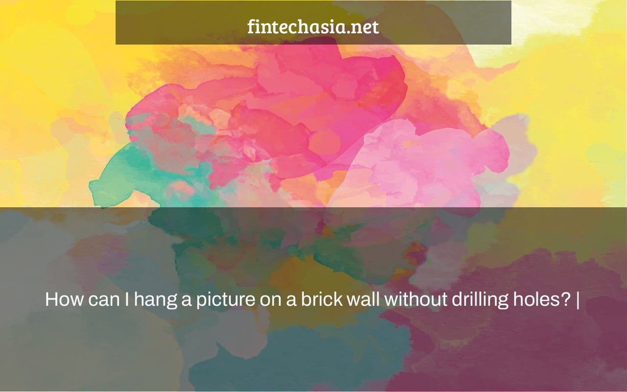 How can I hang a picture on a brick wall without drilling holes? |