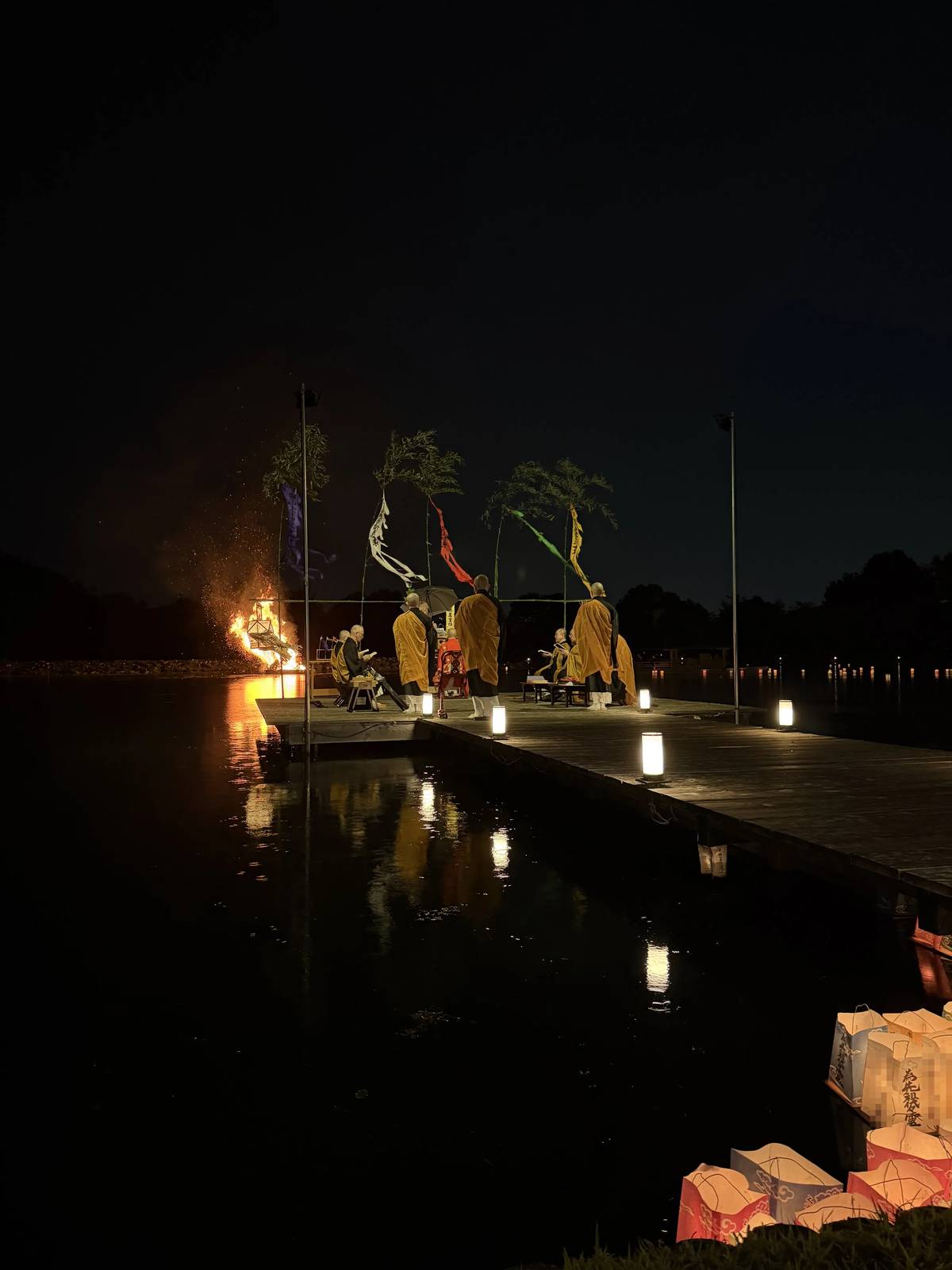 Monks chanting on the stage over Osawa Pond beside the okuribi fire at Daikaku-ji