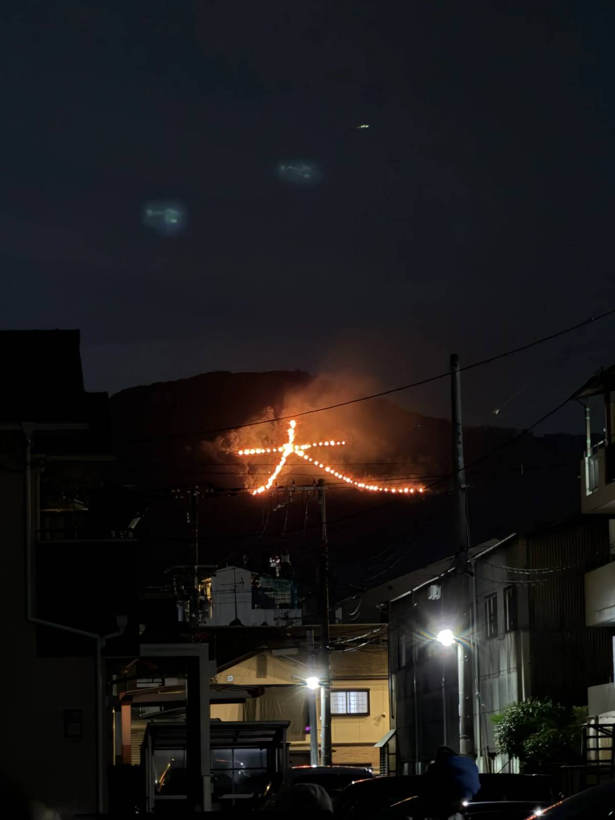 The Daimonji fire seen behind houses and power lines