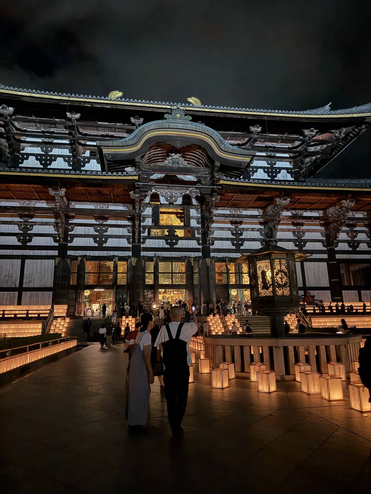 Visitors in front of the Great Buddha Hall of Todai-ji lit up at night