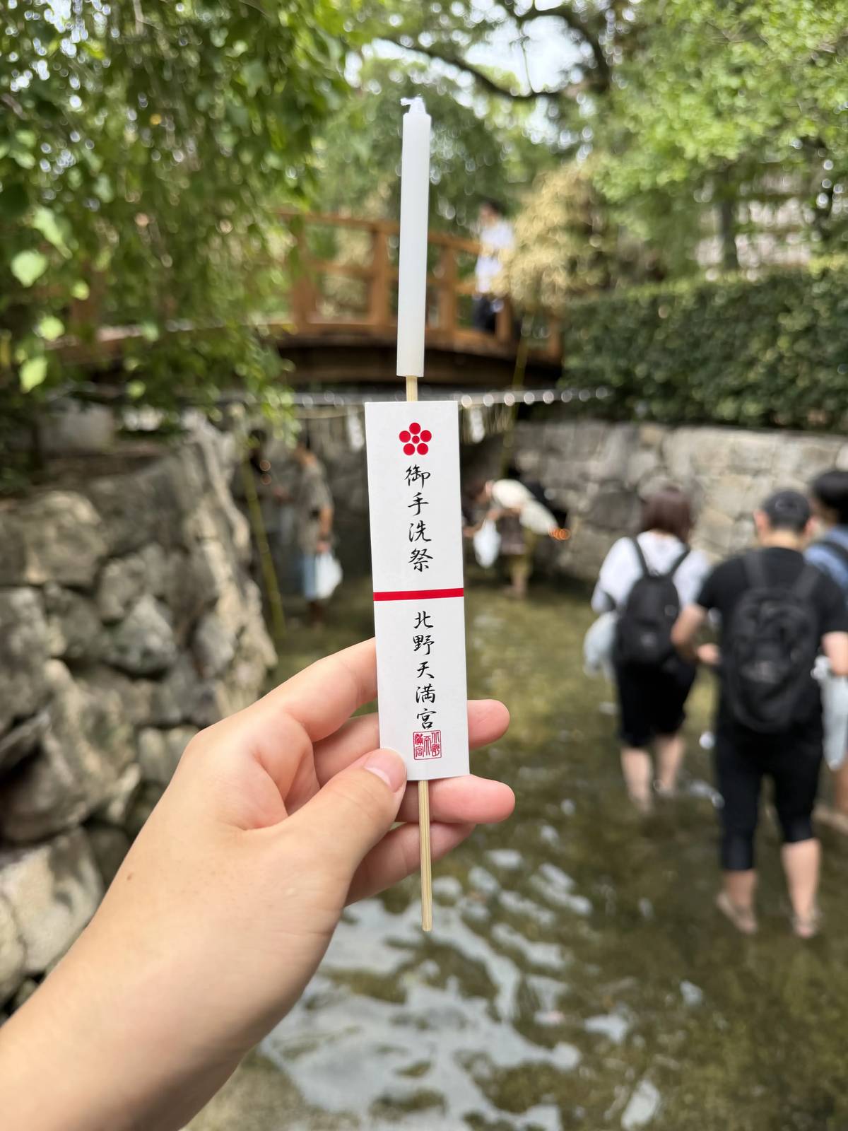 A Mitarashi Festival candle from Kitano Tenmangu, with visitors wading through the stream