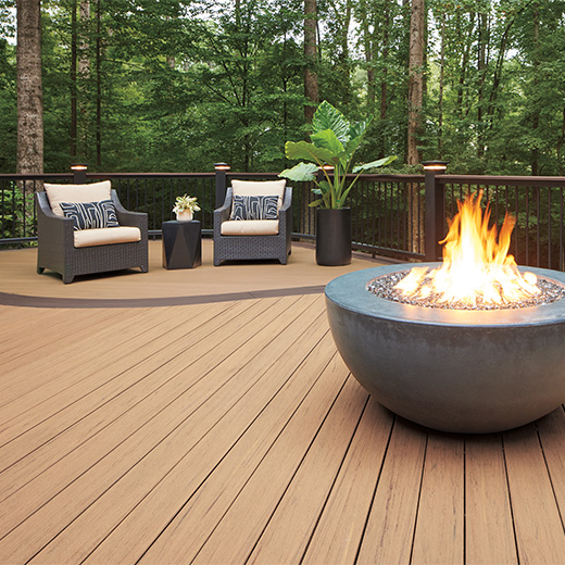 Upgryd custom deck with TimberTech Reserve Antique Leather decking featuring a cozy fire pit, perfect for outdoor gatherings.