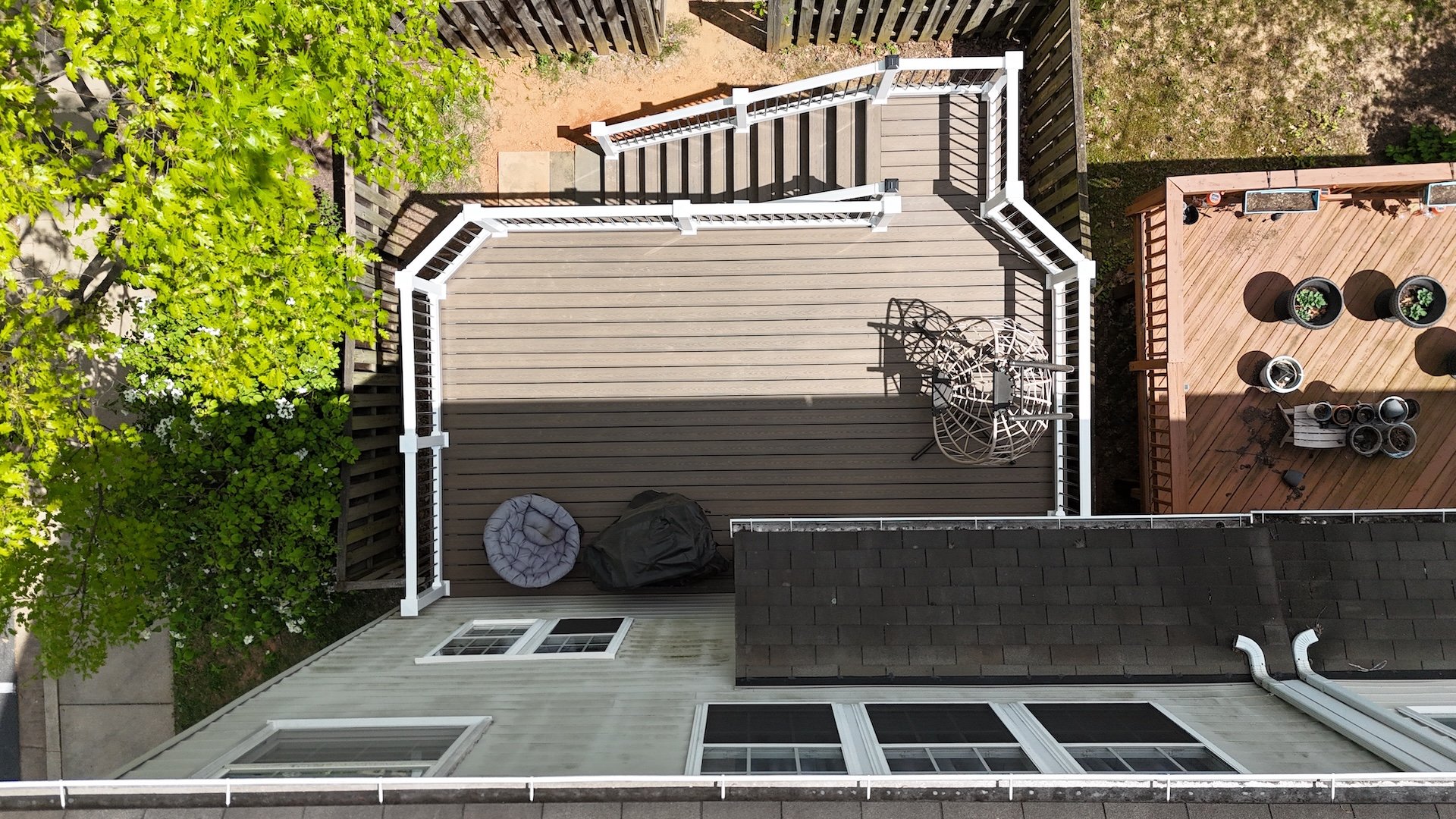 Upgryd's aerial view showcases a stunning custom deck design featuring a tide pool, blending seamlessly with the natural surroundings, highlighting the architectural prowess of Upgryd's Trex decking solutions, perfect for enhancing outdoor living spaces.