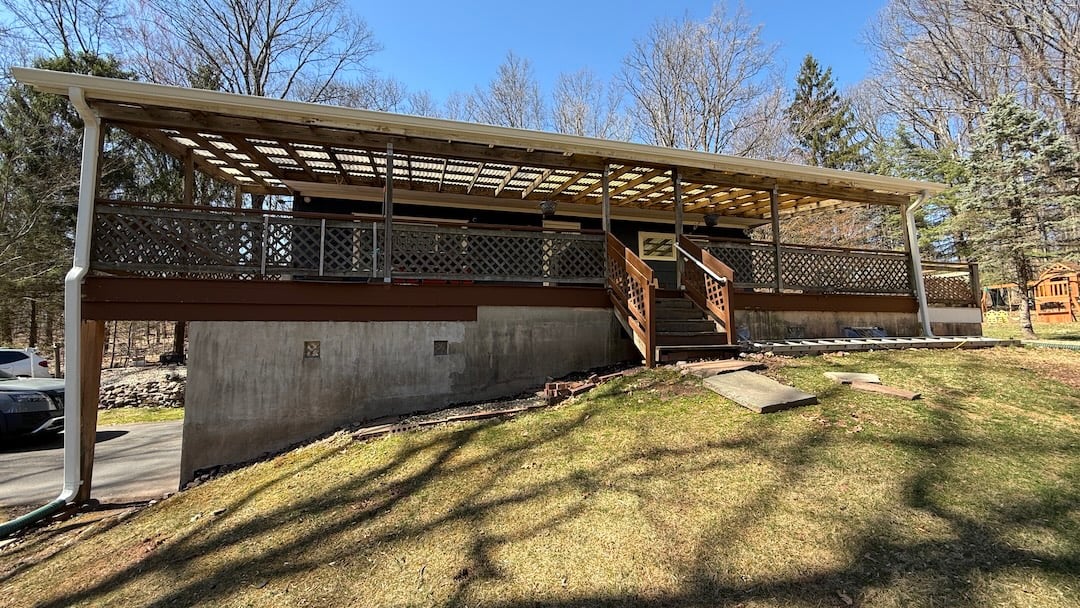 Upgryd: Before and after photos of a covered deck replacement project in Milford, NJ, showcasing the transformation of an old deck.