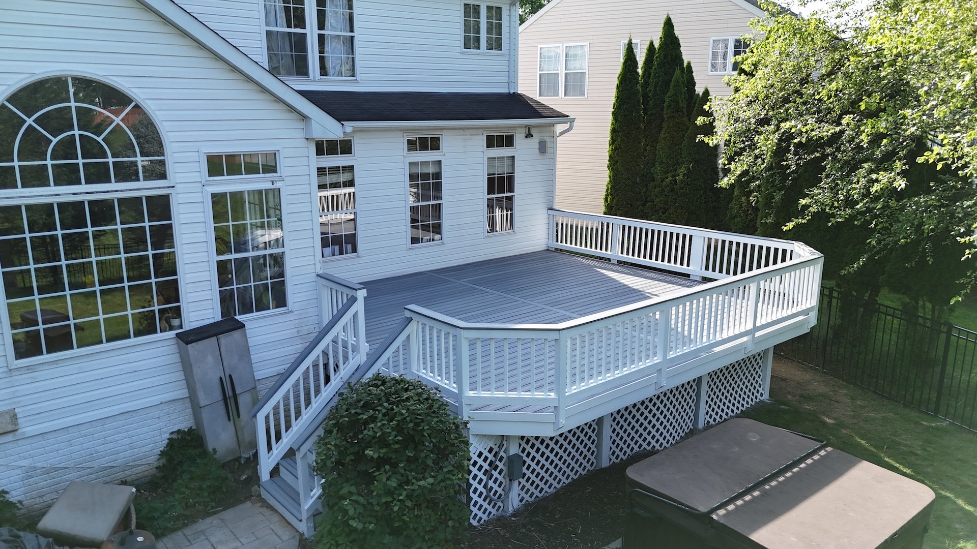 Upgryd Renovated deck featuring durable Trex Enhance Foggy Wharf composite boards with original white wood railings.