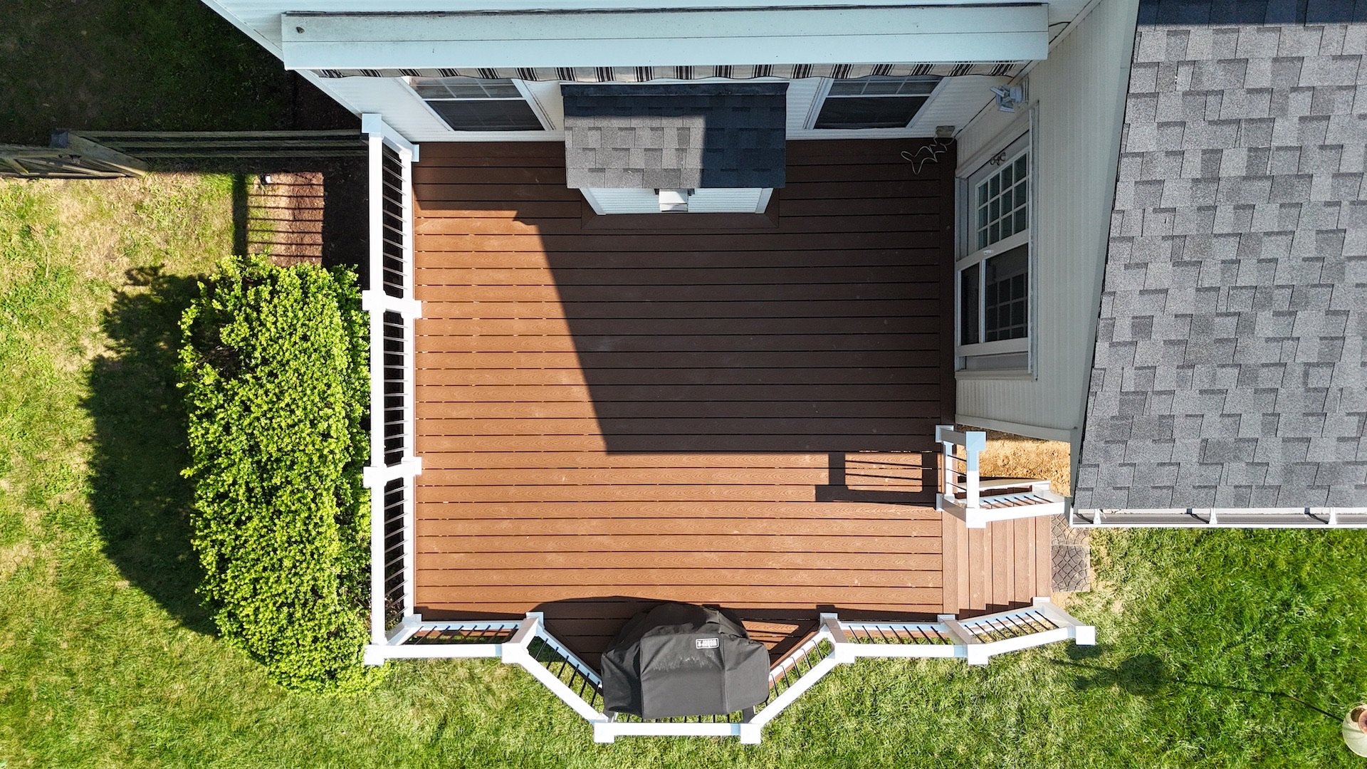 A stunning overhead shot of a newly installed deck featuring Trex Select Saddle boards and vinyl railings.