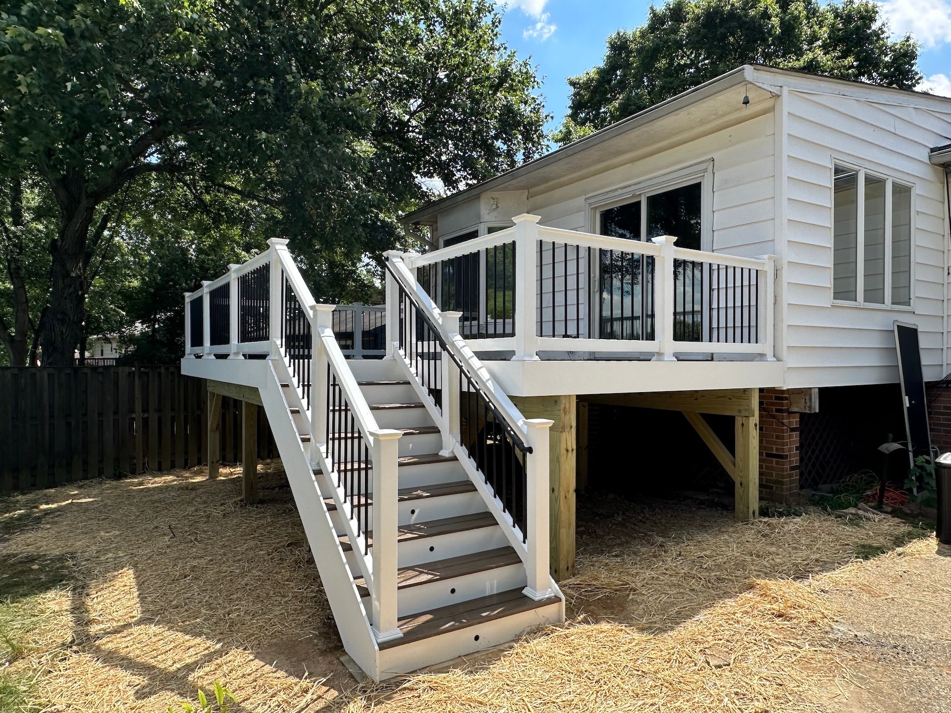 Upgryd's custom deck in Easton, showcasing a backyard view with stairs and elegant white railings, designed for outdoor living.