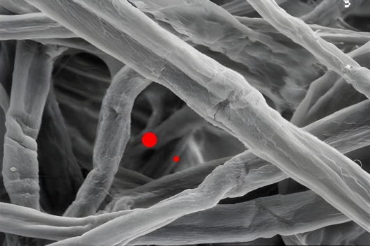 A zoomed in image showing cellulose filter media fibers failing to capture small dirt and dust particles.
