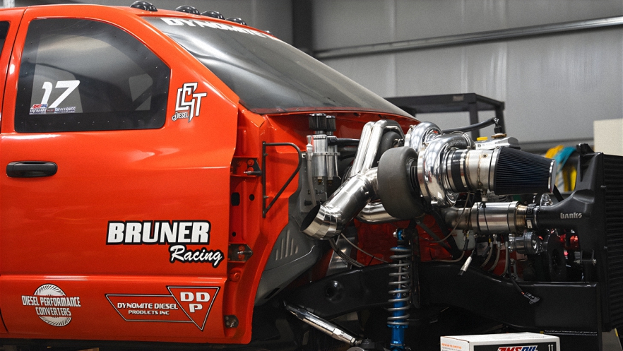 An image of a Bruner Racing high-performance pickup truck and it's high-powered souped-up diesel engine. This racing high-powered truck uses only AMSOIL Fleece Freedom Series premium diesel oil.