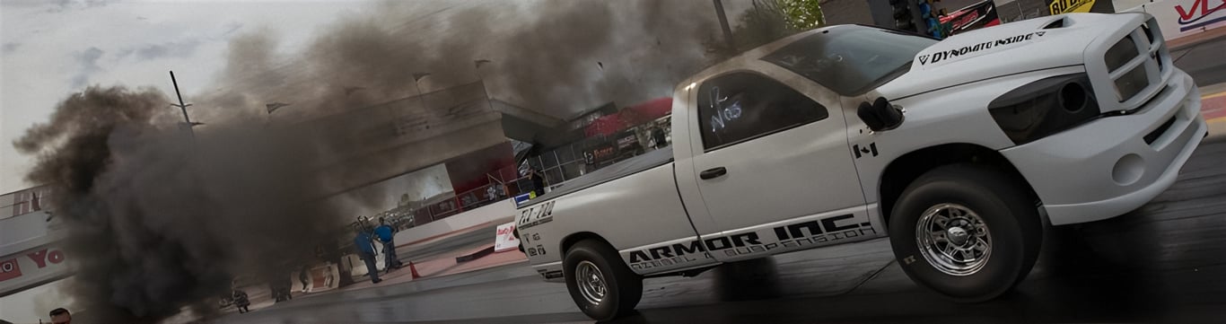 An image of a high-performance racing diesel pickup truck spinning it's tires on the tract. You can depend on AMSOIL Fleece Freedom Series 100% synthetic 15W-50 racing oil to protect your powerful racing truck diesel engines.