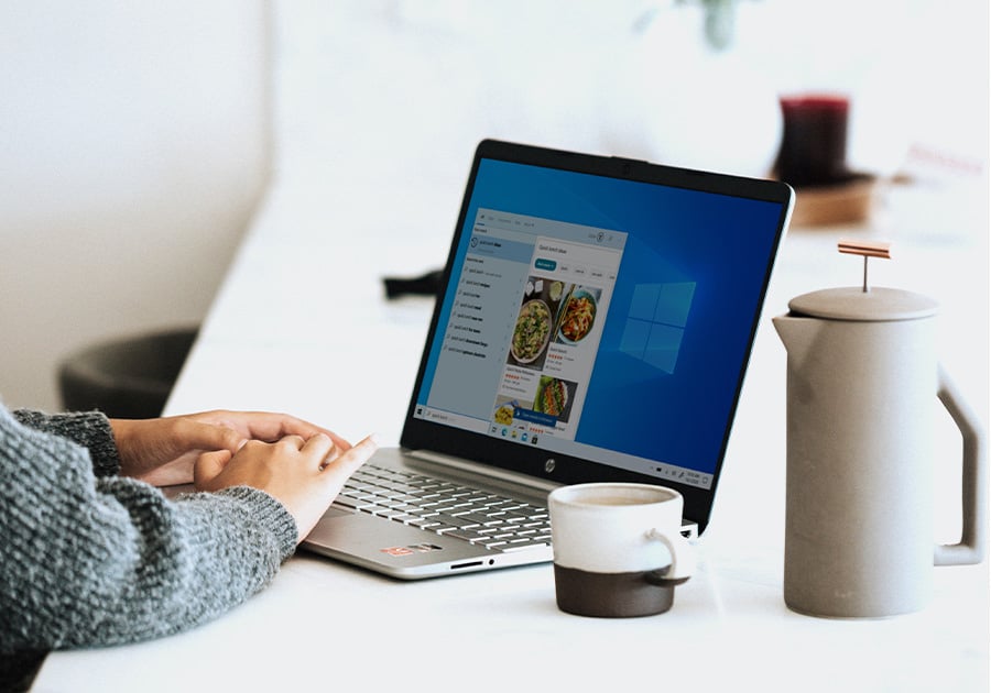 une personne sur son ordinateur avec un café à côté