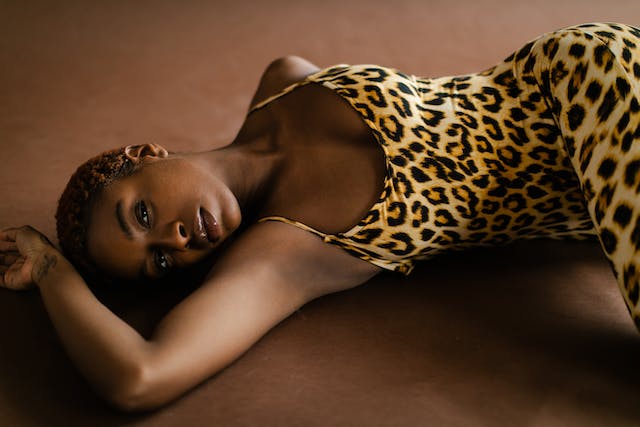 une femme allongée en robe léopard