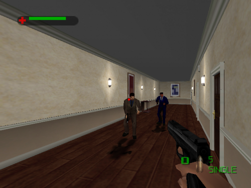 A first-person shooter view inside a residential hallway with beige upper walls and brown wooden flooring. Two armed figures stand in the center distance. A green health bar appears in the top-left corner with a red crosshair icon. Wall-mounted light fixtures and a framed picture are visible on the right wall. A doorway with dark trim stands on the right side. A weapon sight and ammunition counter labeled '5' display in the lower-right corner, with 'SIMPLE' text visible below it.