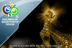 The title screen displays the FIFA World Cup Germany 2006 logo in the upper left corner with blue and white spherical design elements. A large golden World Cup trophy dominates the right side of the screen, rendered in bright yellow with a glowing effect against a dark background. The left portion shows a gradient blue sky transitioning to darker tones. Copyright text reading "© 2006 Electronic Arts Inc. All rights reserved." appears at the bottom in small white text. The overall composition uses a split-screen layout with the logo and trophy as the main focal points on a contrasting dark and light background.