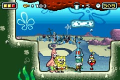 SpongeBob SquarePants stands on a sandy ocean floor in the center of the screen, facing right. Two other characters appear to his right. The background shows an underwater scene with blue water, kelp forests on the left side rendered in green, and coral or rock formations in purple and brown on the right. A score counter reads 5003 at the top right, with additional UI elements showing 0 in the top left corner. The sprite art uses bright colors and blocky pixel detail typical of Game Boy Advance resolution.