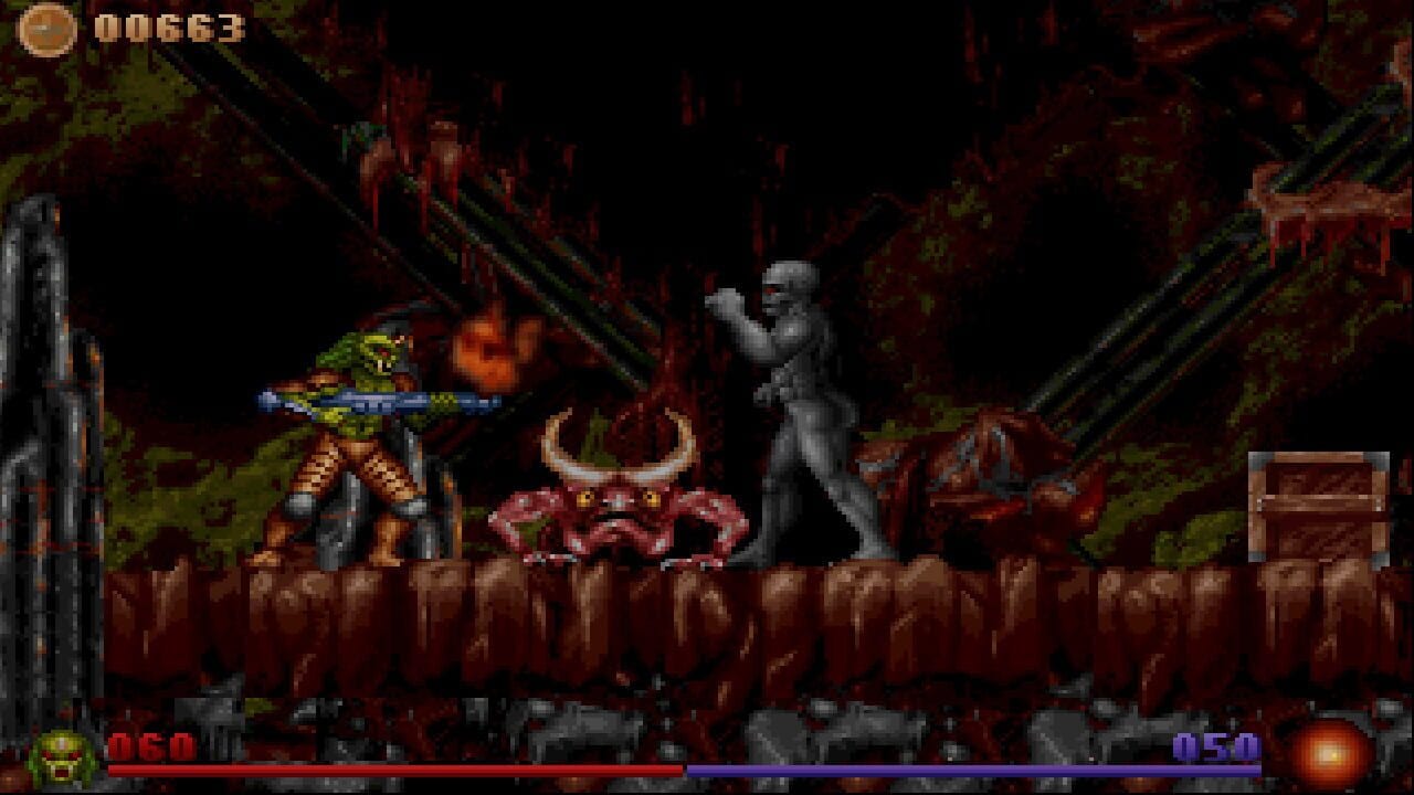 A pixelated side-scrolling action scene shows an armored player character wielding a blue energy weapon facing a red demon-like creature with horns in the center, while a gray skeletal enemy stands to the right. The environment features dark red brick walls with moss-colored trim and a wooden platform forming the ground. A brown wooden crate sits on the right edge. The HUD displays a coin counter reading 000653 in the top-left, health bars at the bottom in red and blue, and an ammo counter showing 050 in the bottom-right. Flames and orange fire effects appear above the enemies.