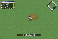A baseball player character stands in the center of a green field viewed from above. The player sprite is brown and small against the bright grass background. A score display in the upper left shows "1 SUN" and "0-1, 0 out" in white text. A diamond-shaped cursor icon appears in the upper right corner. Text at the bottom center reads "49: Sturtze (P)" in yellow font, identifying the pitcher. The overall perspective is top-down, typical of early 2000s Game Boy Advance sports titles.