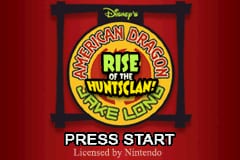 A circular emblem with the Disney logo occupies the center of a red background, displaying "American Dragon Jake Long" and "Rise of the Huntsclan" in green and yellow text. The emblem is framed by a black rectangular border. Below the emblem, white text reads "PRESS START" in a bold sans-serif font. The overall layout is symmetrical and centered, typical of a Game Boy Advance title screen.