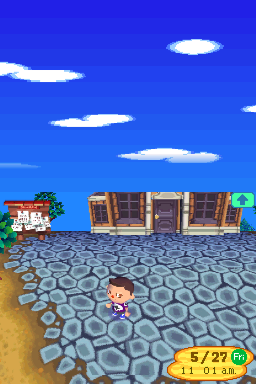 A small character stands on a hexagonal-patterned plaza in an Animal Crossing village scene. Blue sky with white clouds fills the upper half. A row of brown wooden buildings with door openings lines the background, including a shop on the left with an awning. A yellow UI panel in the lower-right corner displays the date and time as 5/29, 11:01am. The scene uses the soft, rounded sprite art style typical of Nintendo DS games.