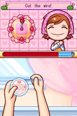 The screen displays a crafting tutorial split into two sections. The top half shows a pink checkered background with the instruction "Cut the wire!" and an illustrated beaded flower wreath with red and purple beads on the left, alongside a smiling girl character wearing a purple headband on the right. Below is a progress bar with red and blue sections. The bottom half depicts two hands holding a circular crafting tool above a pink fabric surface, demonstrating the wire-cutting action required for the activity. The art style uses soft colors and simple cartoon character designs typical of Nintendo DS casual games.