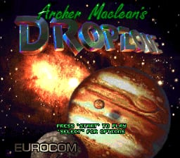 The title screen displays "Archer Maclean's DROPZONE" in large blue and green gradient text at the top. Below the title, a massive explosion effect glows in orange and yellow against a starfield background, with a detailed spacecraft or planet surface visible in the lower portion rendered in brown and tan tones. At the bottom, "EUROCOM" appears in white text, and a message reads "PRESS BUTTON TO START" followed by additional smaller text. The overall composition uses a dark space backdrop with pixelated sprite-style graphics typical of SNES-era visuals.