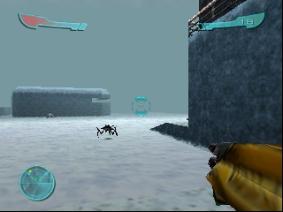 A first-person view shows a yellow-gloved hand holding a rifle on the right side of the screen. The snowy outdoor environment stretches ahead with large dark rectangular structures on either side. Two blue health or ammo bars appear at the top left and right. A small radar or compass display sits in the lower left corner. A small dark figure stands in the distance on the white ground. The sky is overcast gray-blue.