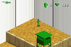 A green plastic army man soldier stands on a tan, sand-textured isometric platform against a corrugated metal wall backdrop. The HUD displays a green heart icon, a green soldier icon, and the number 400 in the upper right corner. A bright green weapon pickup or item sits elevated on the platform surface. The low-resolution sprite graphics and isometric perspective are characteristic of Game Boy Advance rendering.