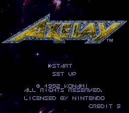 The Axelay title screen displays the game's logo in yellow metallic lettering at the top center against a dark starfield background. Below the logo, menu options appear in white text reading 'START', 'SET UP', and copyright information crediting 1992 Konami and Nintendo licensing. The entire screen uses a black background with purple and blue tinted stars scattered across it, creating a space-themed aesthetic typical of early SNES arcade-style shooters.