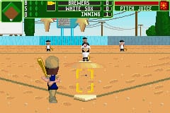 A baseball field is shown from a top-down perspective with a batter in the center foreground and three fielders positioned across the sandy infield. The UI displays game information at the top including team names and score. The scoreboard reads "BASEBALL" with yellow text. The background shows a simple stadium with bleachers, green grass areas, and a corrugated fence. The graphics use a low-resolution sprite-based style typical of Game Boy Advance games, with a limited color palette of greens, browns, tans, and blues.