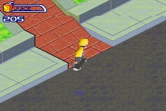 A skateboarder character stands on a red brick rooftop area in an isometric perspective view. The character is positioned on the left side of the platform. At the top left, a blue health or energy bar and a score display reading "205" are visible in the HUD. The background shows green grass areas and gray concrete sections creating an urban skate park environment. The graphics use a bright, colorful GBA-style palette with clear sprite and tilework typical of early 2000s handheld gaming.