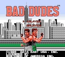 The title screen features "BAD DUDES" in large red letters at the top. Below sits a stylized black-and-white cityscape with skyscrapers. Two muscular male characters in red clothing stand centered in the foreground with their fists raised. A green horizontal line separates the characters from the city background. At the bottom, "1989 DATA EAST USA INC" and "PUSH START BUTTON" text appear in white. The pixel art uses a bright blue sky background and displays typical NES-era sprite resolution and color palette.