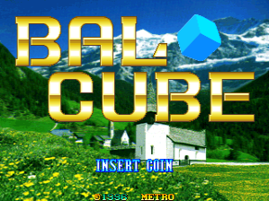 Large yellow block letters spelling "BAL CUBE" dominate the upper half of the screen over a naturalistic background of green grass, blue sky, and snow-capped mountains. A cyan-colored cube sits positioned in the center-right area. Below the title, white text reads "INSERT COIN" in a standard arcade font. At the bottom, red text displays "RETRO" and "METRO," indicating the developer. The overall aesthetic uses a clear color palette with vibrant blues and greens against the golden title typography.