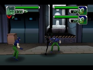 Two characters face each other on a dark urban street with tall buildings and loading dock doors in the background. The character on the left wears green and blue clothing, while the character on the right wears a black suit with green accents. A health bar and energy counter display at the top left showing 100 health points. Additional UI elements appear in the top right corner showing character portraits and status information. The scene uses a dark color palette with pixelated sprites rendered in a fighting game style layout.