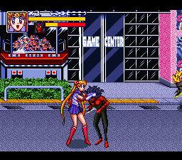 Two characters in fighting stance face each other on a city street, with the left character wearing red and white attire. A storefront with signage occupies the upper left, while a pink-bordered grid pattern fills the right side of the screen. The scene uses 16-bit sprite graphics with a purple-toned street and blue night sky. Health bars and game UI elements appear at the top of the screen, indicating an active combat encounter.