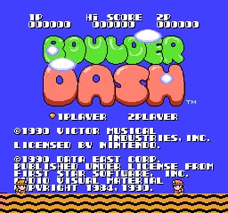 The title screen displays 'BOULDER DASH' in large green pixelated letters centered on a bright blue background. Below the title sit two red circular characters with simple facial features. The upper portion shows three white score/level indicators reading "1P SCORE", "HI SCORE", and "2P". Copyright text and publisher information for SAS and Data East USA appear at the bottom, followed by game credits. A tan-colored wavy pattern representing dirt or terrain runs along the bottom edge of the screen.