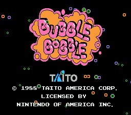 The title screen displays 'BUBBLE BOBBLE' in large pink and orange bubble-styled lettering against a black background, surrounded by small colored squares and circles. Below the title, the TAITO logo appears in blue and cyan. Copyright text reads '© 1988 TAITO AMERICA CORP.' with 'LICENSED BY' and 'NINTENDO OF AMERICA INC.' displayed underneath. Small geometric shapes scattered across the screen create a simple decorative pattern.