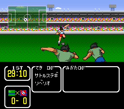 A soccer player in dark uniform performs a sliding tackle on the green pitch while an opponent in lighter uniform approaches from the right. The stadium background shows packed stands with red seating and a scoreboard structure. A HUD overlay displays the game timer at 29:10, player status indicators on the left showing 0-0, and Japanese text dialogue in a black box at the bottom. The sprite-based graphics use flat pixel art typical of SNES-era sports games, with a clear view of the field and character animations.