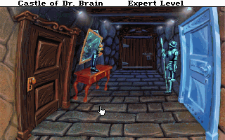 A first-person view of a stone corridor with wooden doors on either side. The left door stands open revealing warm brown wood tones, while the right door is painted bright blue. A character in red clothing stands in the center of the hallway. The floor consists of gray stone tiles arranged in a checkered pattern. At the top of the screen, "Castle of Dr. Brain" appears on the left and "Expert Level" on the right. The 3D perspective uses flat-shaded polygons typical of early DOS adventure games, with a brown and blue color palette dominating the scene.