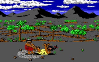 A caveman character lies on the ground in the center of a desert landscape, surrounded by scattered rocks and brown terrain. Palm trees and green vegetation dot the sandy ground, with gray mountains visible in the background against a bright blue sky with white clouds. The 16-color palette and low-resolution sprites are typical of DOS-era graphics. A horizontal brown strip divides the upper sky from the lower terrain, creating a two-tier composition.