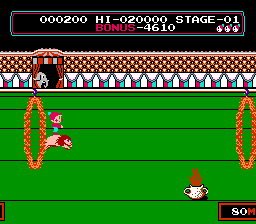 A red-suited character stands on a green ground level between two flaming ring obstacles in an 8-bit circus stage. The top border displays a red brick circus tent facade with white striped panels below. The HUD shows score 000200, hi-score 020000, stage 01, and a health bar with three units. A spinning timer counter reads 90 in the lower right. Pixel art uses a limited palette of red, white, green, and tan tones typical of NES-era graphics.