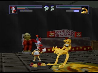 Two clay-textured fighters face off in a boxing ring arena. The left character wears red gloves and clothing, while the right character is yellow. A red neon sign reading "BOD'S SHIT SUGAR" hangs above the ring. Health bars for both fighters display at the top of the screen in blue and gray. The arena floor is gray with a dark background, and small decorative elements frame the scene on either side. The character models and environment use a low-polygon, clay-like visual style characteristic of early N64 graphics.